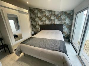 una camera con un letto in una stanza con carta da parati di Villa des Huniers à La Chaume a La Chaume