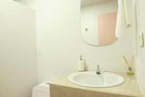 a bathroom with a sink and a toilet and a mirror at Hotel Bania travels in Guatapé
