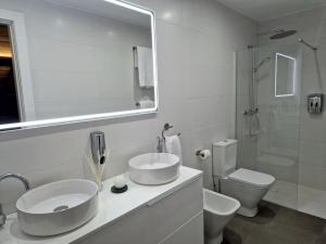 a bathroom with two sinks and a toilet and a mirror at Dúplex de diseño Jaén Centro-Catedral in Jaén +10 photos