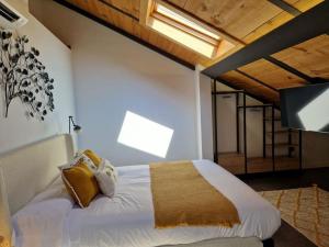- une chambre dotée d'un grand lit avec des draps et des oreillers blancs dans l'établissement Dúplex de diseño Jaén Centro-Catedral, à Jaén