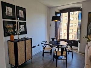 a living room with a table and chairs and a window at Dúplex de diseño Jaén Centro-Catedral in Jaén