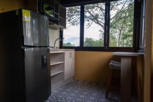 a kitchen with a stainless steel refrigerator and a window at Hotel El Eden Country in Armenia