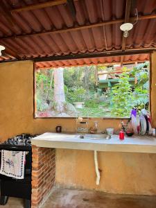 cocina con fregadero y ventana en Auá Hostel, en Petrópolis