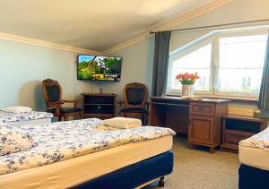 um quarto com 2 camas, uma secretária e uma televisão em Noclegi Prestige em Siewierz