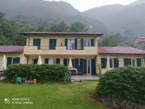 a large house with a yard with a house at Villa Oliveto apartments in Oliveto Lario