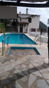 una piscina frente a una casa en El Nogal en Bubión