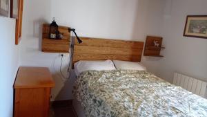 1 dormitorio con cama y cabecero de madera en El Nogal en Bubión