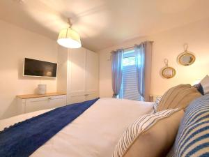 1 dormitorio con 1 cama, TV y ventana en Ostseeherz, en Zingst