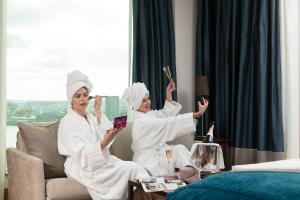 two women in white robes sitting on a couch at InterContinental London - The O2 in London