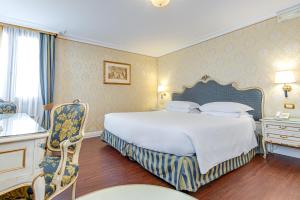 a bedroom with a large bed and a table and chairs at Hotel Antiche Figure in Venice
