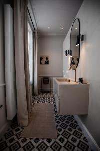 uma casa de banho com um lavatório e um espelho em Villa Ostinato em Oostende