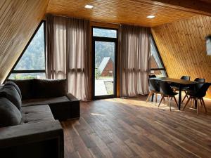 a living room with a couch and a table with chairs at Green Villa Resort Grey in Dilijan