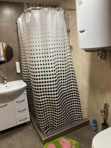 La salle de bains est pourvue d'une douche avec un rideau de douche blanc et noir. dans l'établissement Green Villa Resort Grey, à Dilidjan
