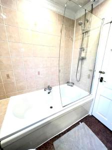 een badkamer met een douche en een bad met een wastafel bij Spacious 3 bedrooms house in Bolton Upon Dearne Up to 6 Guests! 