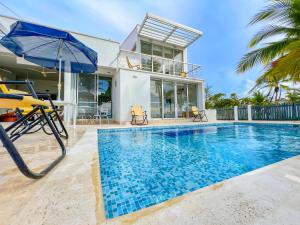 a villa with a swimming pool and a house at Quinta Del Mar El francés in Tolú