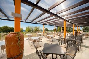 un patio con mesas y sillas y un jarrón grande en Easyatent Safari tent Park Umag, en Umag