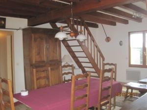 un comedor con una escalera de madera y una mesa en Les Chênes 2 - cadre verdoyant en Eugénie-les-Bains