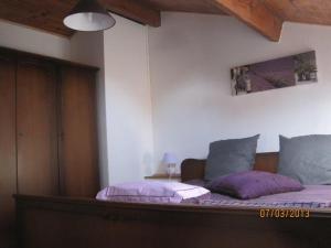 a bedroom with a bed with purple pillows at Les Chênes 2 - cadre verdoyant in Eugénie-les-Bains