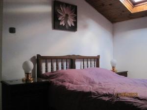a bedroom with a bed and a flower picture on the wall at Les Chênes 2 - cadre verdoyant in Eugénie-les-Bains