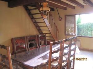 uma sala de jantar com uma mesa de madeira e cadeiras em Les Chênes 2 - cadre verdoyant em Eugénie-les-Bains
