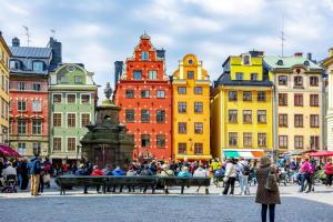 a group of people walking around a city with buildings at Cosy Apartment in heart of Stockholm Sweden in Stockholm