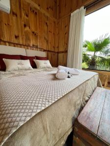 - une chambre avec un grand lit et une grande fenêtre dans l'établissement Pousada- Cabana Gala Vale das Macieiras Urubici, à Urubici