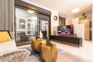 a living room with a large tv and a couch at Central and Luxury New 2BR&2Bth - Private Parking in Jerusalem