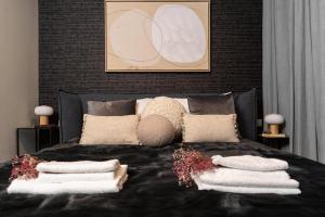 a bedroom with a black bed with pillows on it at Central and Luxury New 2BR&2Bth - Private Parking in Jerusalem