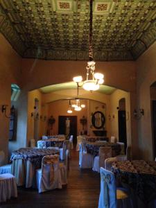 Roka Plaza Hotel Boutique في أمباتو: غرفة طعام بها طاولات وكراسي وثريا