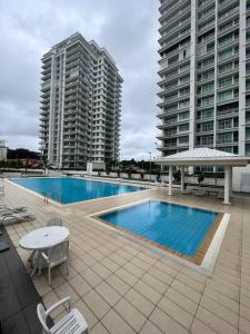 a large swimming pool with two tall buildings at Bay Resort Condominium 3-bedrooms with Swimming Pool near the Seaside in Miri