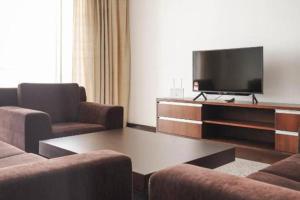 een woonkamer met 2 stoelen en een flatscreen-tv bij Bay Resort Condominium 3-bedrooms with Swimming Pool near the Seaside in Miri