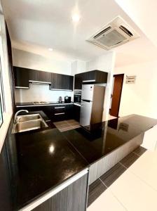 een keuken met een zwart aanrecht en een wastafel bij Bay Resort Condominium 3-bedrooms with Swimming Pool near the Seaside in Miri