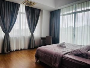 a bedroom with a bed and large windows at Bay Resort Condominium 3-bedrooms with Swimming Pool near the Seaside in Miri