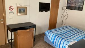 a room with a bed and a desk and a mannequin at Room Saronno + B&B in Saronno