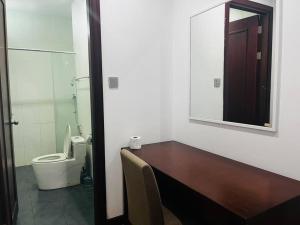 a bathroom with a toilet and a sink and a mirror at Bay Resort Condominium 3-bedrooms with Swimming Pool near the Seaside in Miri