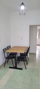 una mesa de madera y sillas en una habitación en Depto en Tandil Garibaldi 388 en Tandil