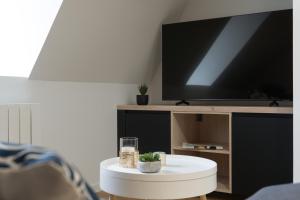 een woonkamer met een witte tafel en een tv bij Le Chirac 5 T2 Centre Historique Rodez in Rodez