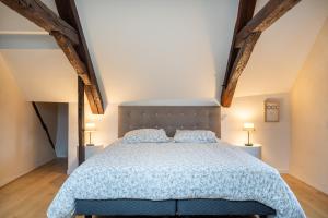 een slaapkamer met een bed met een blauw dekbed en 2 lampen bij Le Chirac 5 T2 Centre Historique Rodez in Rodez