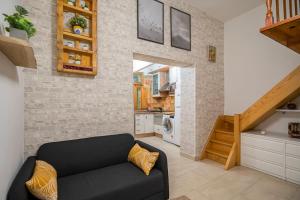 salon z czarną kanapą i ceglaną ścianą w obiekcie Studio near Embajadores and Atocha (R.ATOCHA) w Madrycie