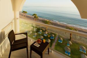 a balcony with a table and chairs and the ocean at Ona Marinas de Nerja Spa Resort in Nerja