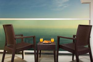 two chairs and a table with two glasses of orange juice at Ona Marinas de Nerja Spa Resort in Nerja