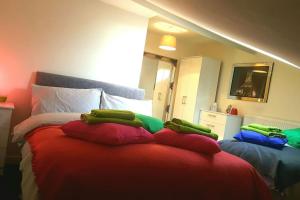 a bedroom with a bed with red and green pillows at Large 6 bedroom duplex - perfect for large family in Liverpool