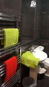 a bathroom with green and red towels and a sink at Large 6 bedroom duplex - perfect for large family in Liverpool