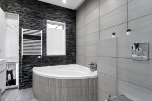 a bathroom with a bath tub and a window at Relaxing Reykjavik Apartment in Reykjavík