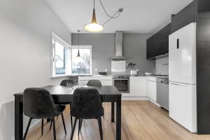 a kitchen with a black table and black chairs at Relaxing Reykjavik Apartment in Reykjavík