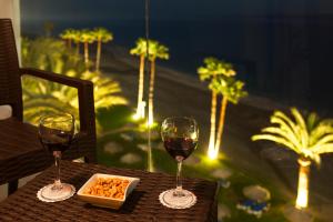 two glasses of wine and a bowl of food on a table at Ona Marinas de Nerja Spa Resort in Nerja