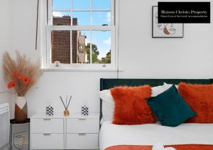 a bedroom with a bed with colorful pillows and a window at Kirkwall 1Bedroom Apt Sleeps 4 with Wifi & Lesiure By Maison Christo Property Short Lets & Serviced Accommodation in London