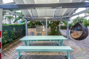a picnic table under a pergola with a grill at Dover Court Apartments - Steps to St Lawrence Gap in Christ Church