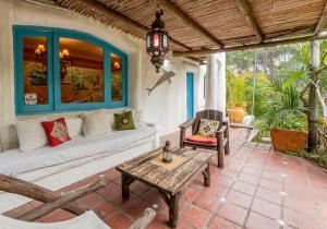 un patio con sofá, mesa y sillas en El Delfin, en Punta del Este
