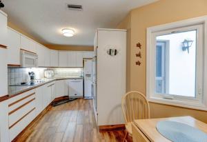 a kitchen with white cabinets and a table and a window at Pool Golf and Welcome to ROCKVILLE Available in Daytona Beach